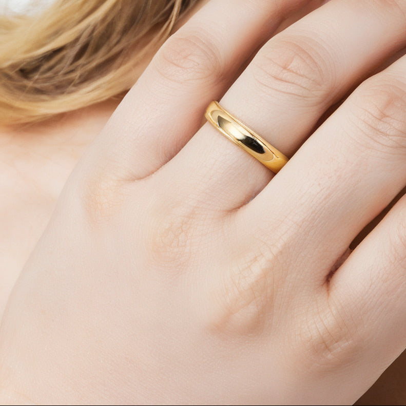 Polished 18ct yellow gold wedding band worn on hand — example finished ring from couples lost wax carving workshop Cornwall