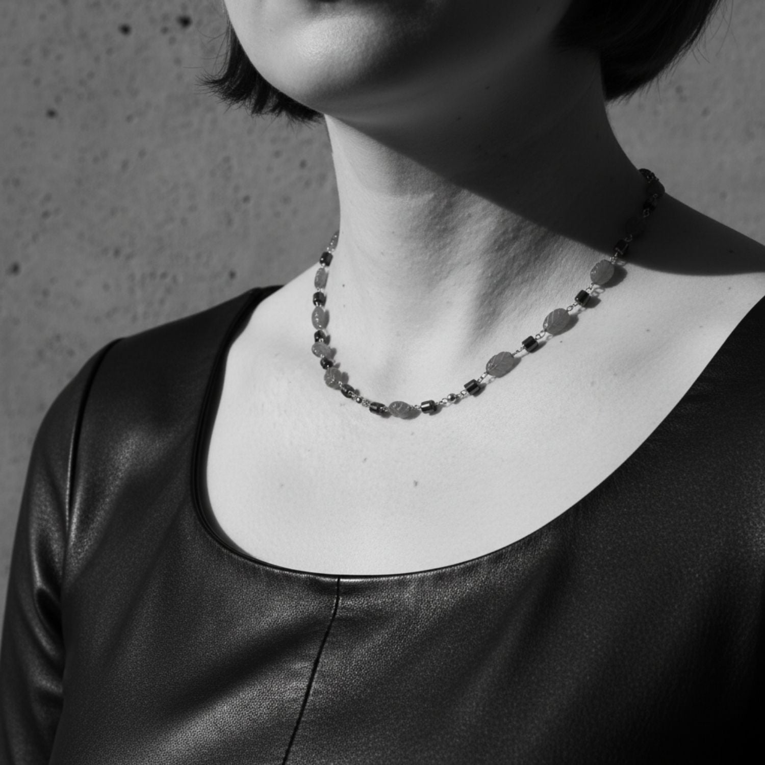 Person wearing a necklace with a plain background