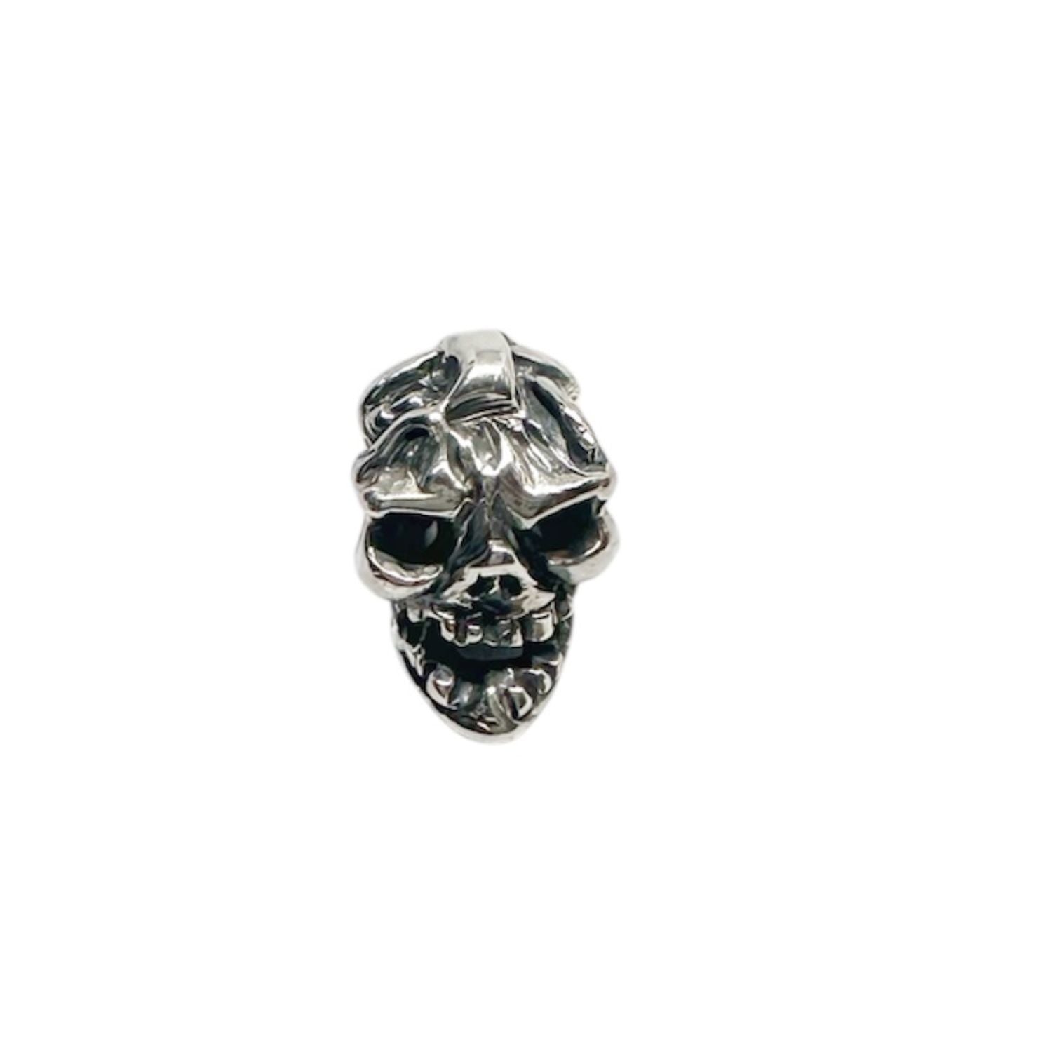 Sculptural skull pendant detail showing deep carved anatomical features and oxidised recesses