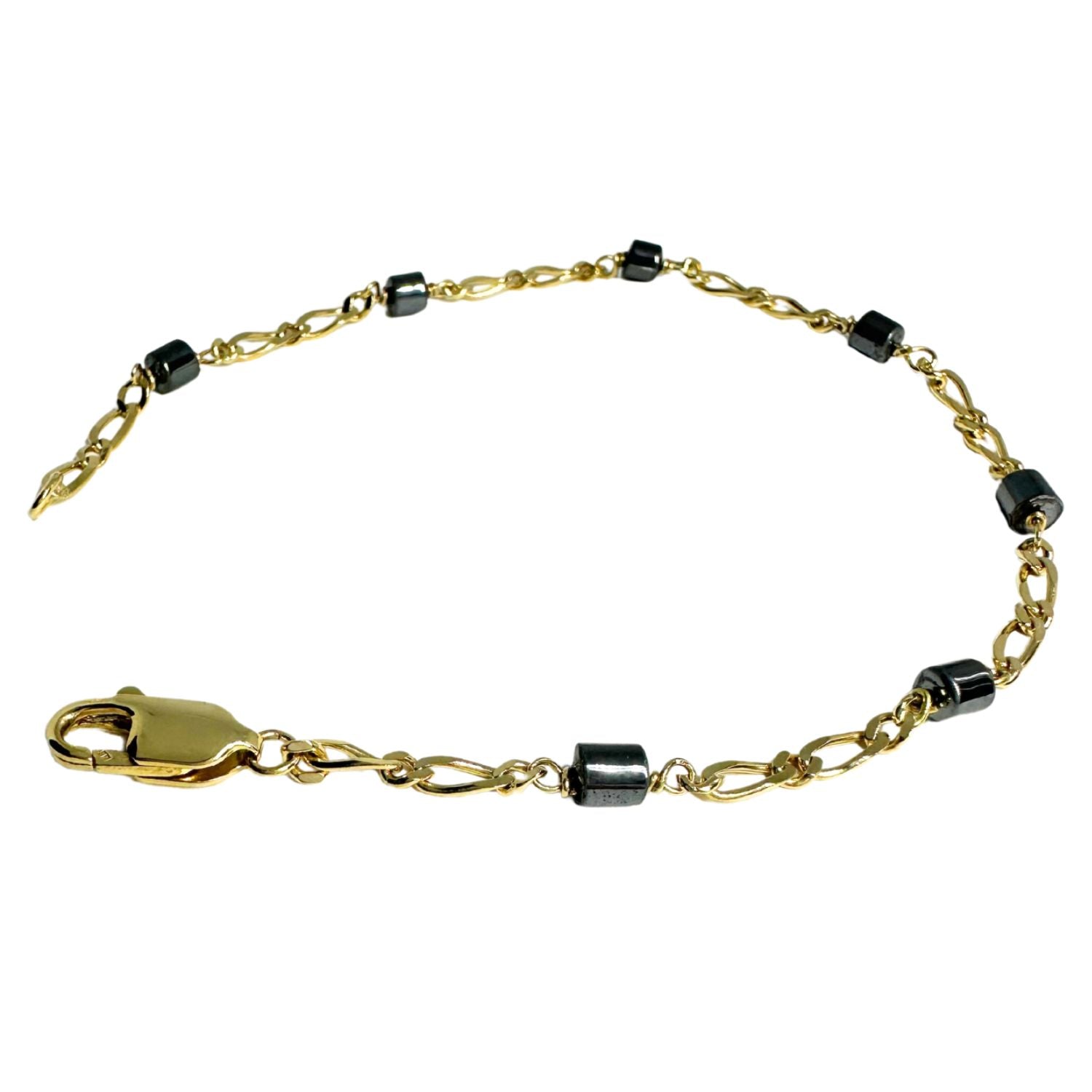 Close-up of natural hematite stone set in 18ct yellow gold Figaro chain bracelet — dark metallic mineral against warm gold, one-of-a-kind - Tg-Jewellery By Tamara Gervasio