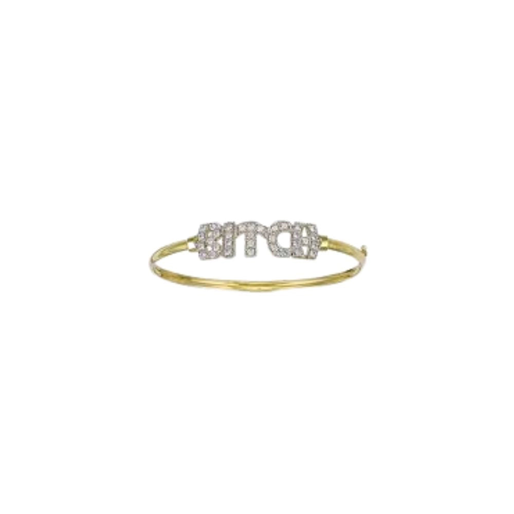 A gold 18ct yellow and white bangle bracelet featuring a central rectangular cluster of diamonds pavé-set stones spelling out 'BITCH' handmade by Tg-Jewellery