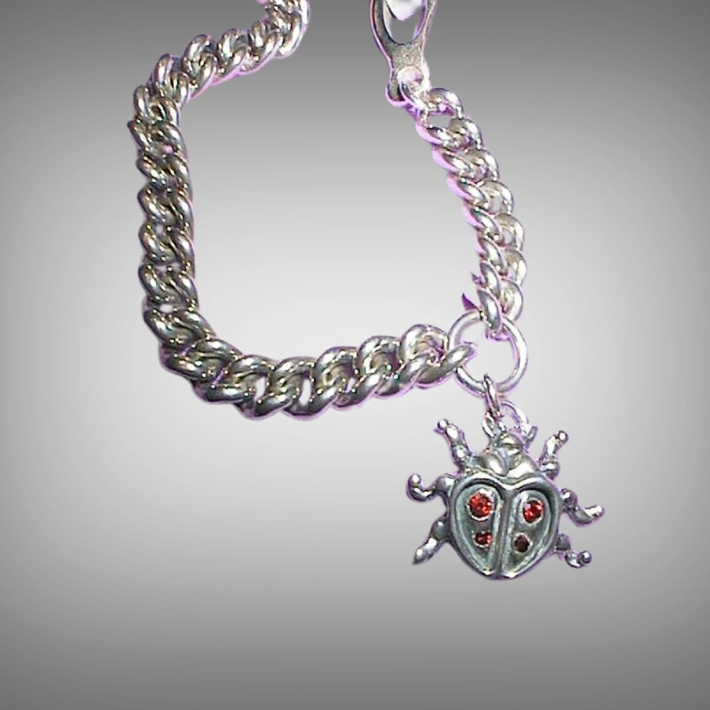 A sterling silver curb chain bracelet with a ladybug charm featuring garnet gemstones, Tg-Jewellery by Tamara Gervasio