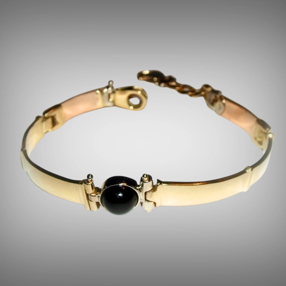 A gold 18ct yellow and rose bangle bracelet with a central black onyx stone, hand carved from lost wax by Tg-Jewellery