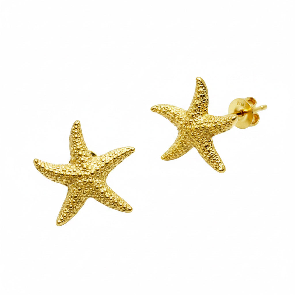Gold starfish earrings on a white background