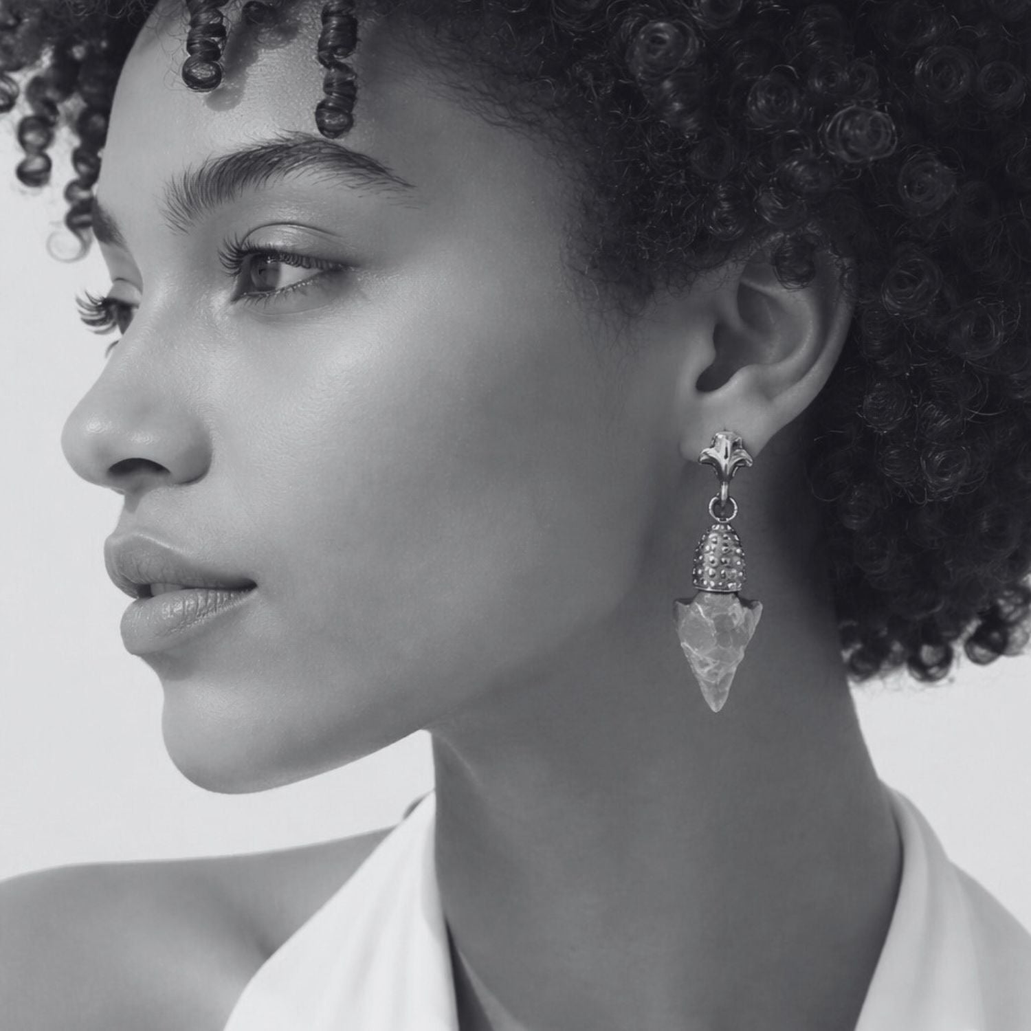 Black and white close-up of a woman wearing a dangling earring.