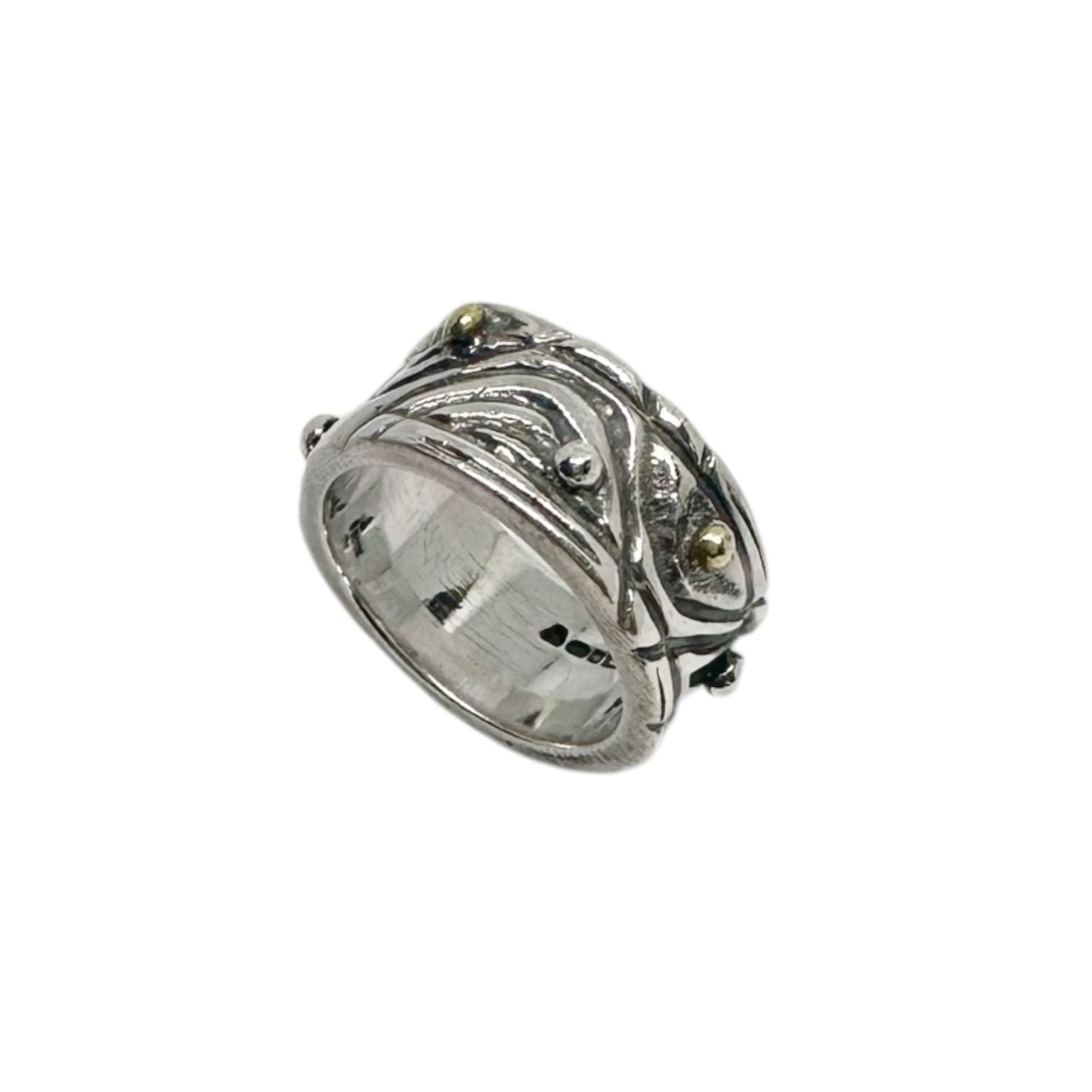 Close-up showing layered organic lines and silver and brass pebble details