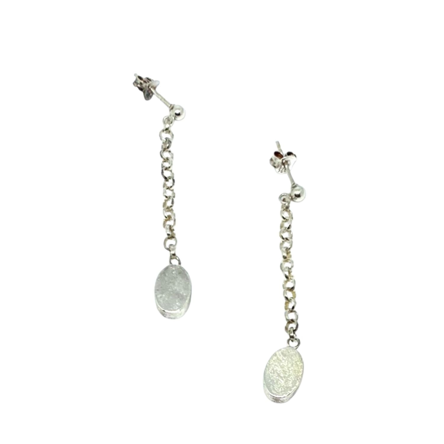 Close-up showing satin texture and high-polish contrast finish oval drop stud earrings 