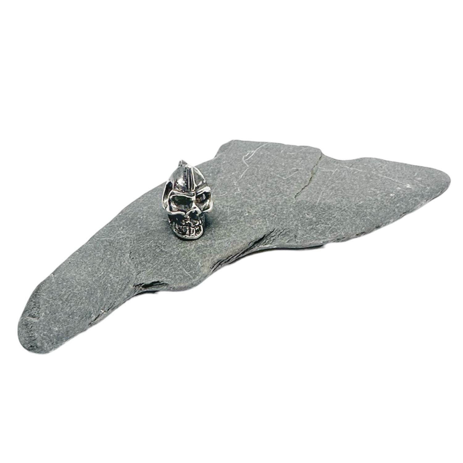 Side-drilled skull bead pendant showing texture and oxidised recesses, handmade lost wax cast silver