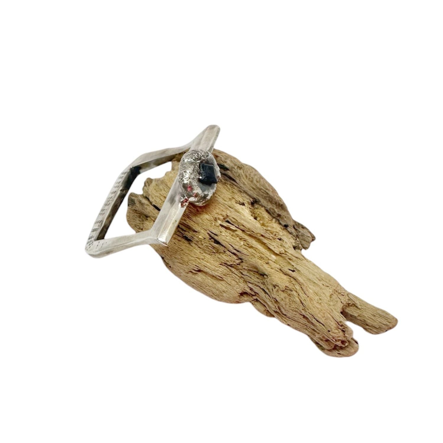 Handcrafted recycled sterling silver ring with angular band and molten pebble setting holding a 3.5mm square sapphire, partially emerging from the surface - Tg-jewellery By Tamara Gervasio
