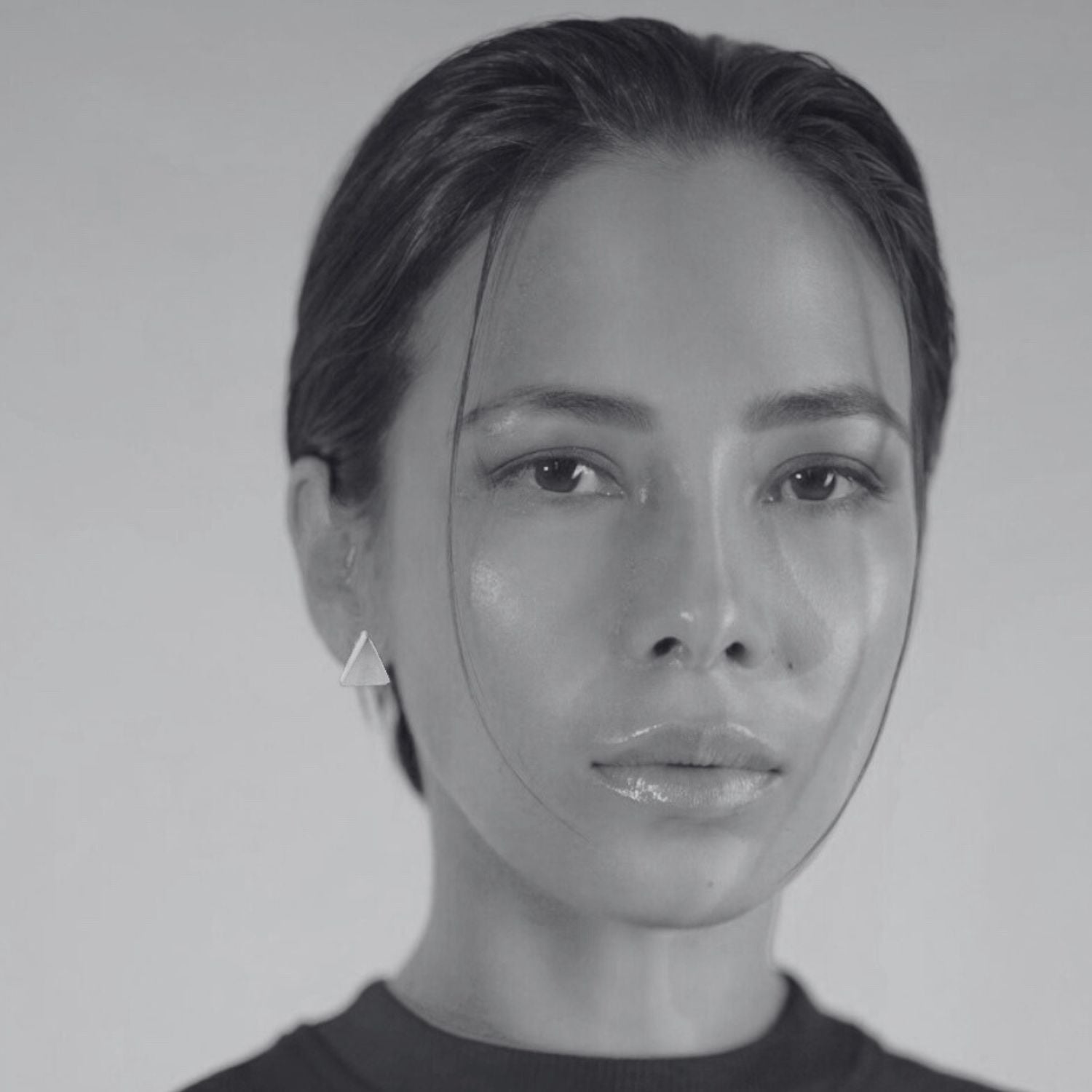 Model wearing sterling silver 925 triangle stud earrings, showing scale and minimal architectural styling